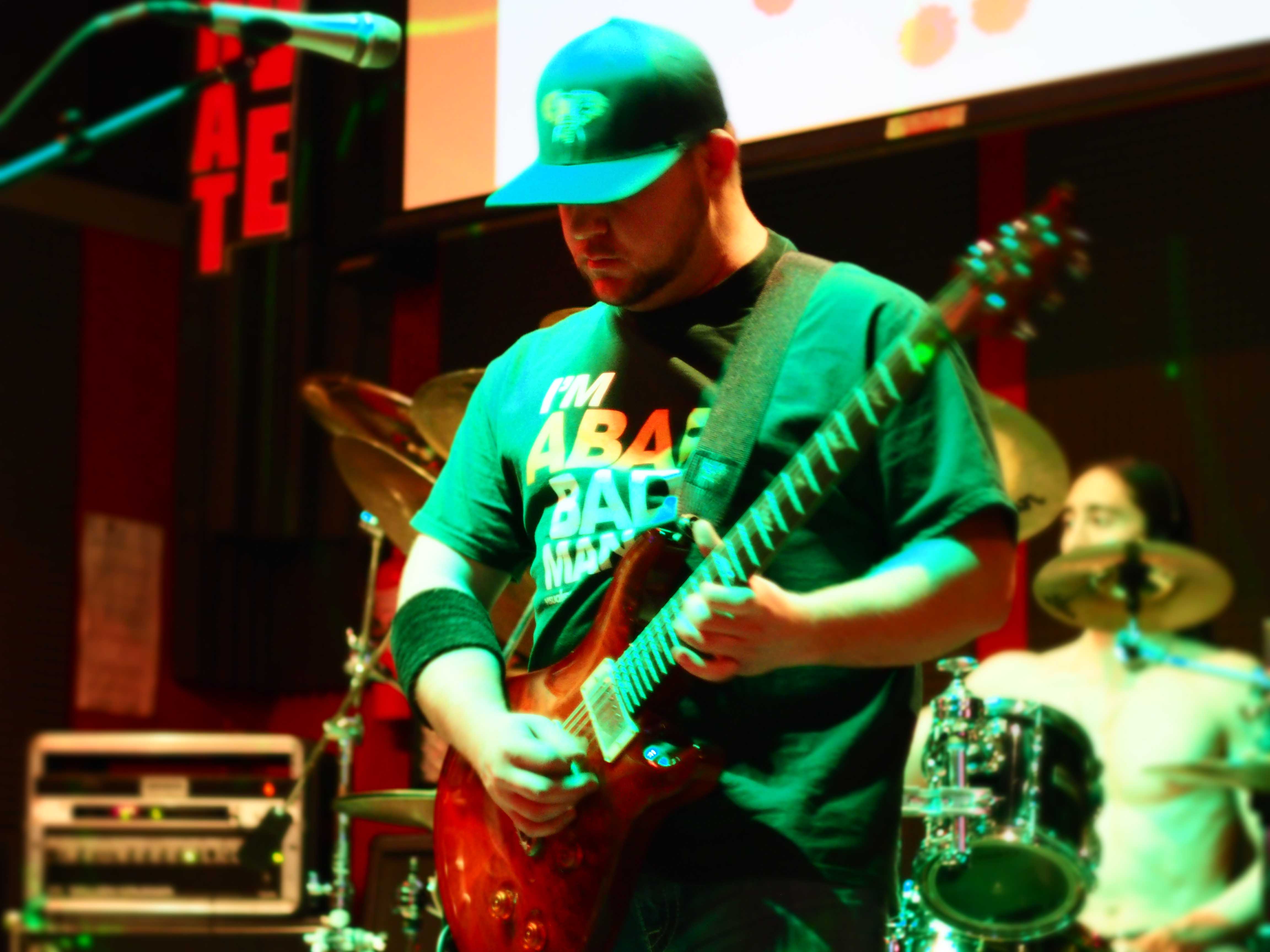 Mike Perillo playing a red guitar onstage